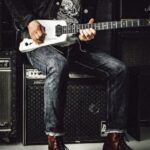 Amplifier - Man Sitting on Guitar Amplifier Playing Electric Guitar