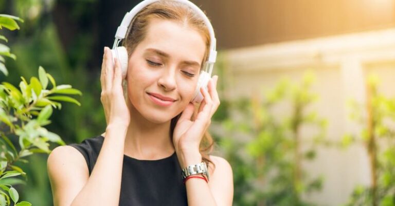 Headphones - Woman Wearing Black Sleeveless Dress Holding White Headphone at Daytime