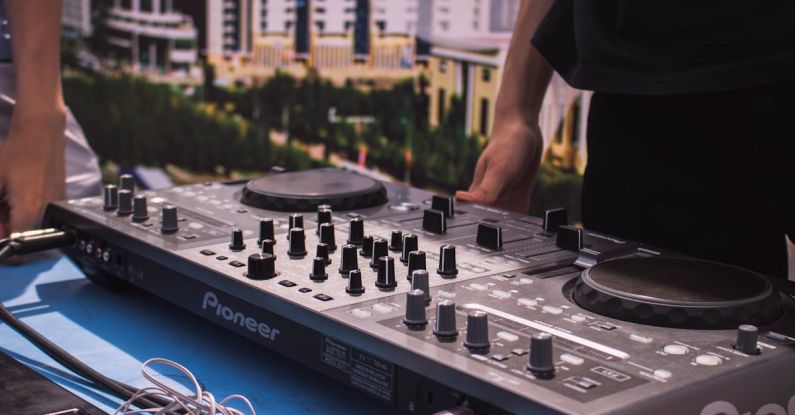 Turntables - Person in Black T-shirt Standing in Front of Black Dj Mixer