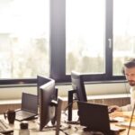 Services - Man With Headphones Facing Computer Monitor